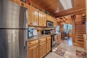 Una cocina moderna con electrodomésticos de acero inoxidable, armarios de madera y vistas al exterior.