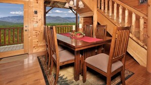 A wooden cabin with a dining area, a staircase, and a scenic mountain view. - Romantic Escape with panoramic Mountain Views, great location 2.5 steps to enter (Sevierville)