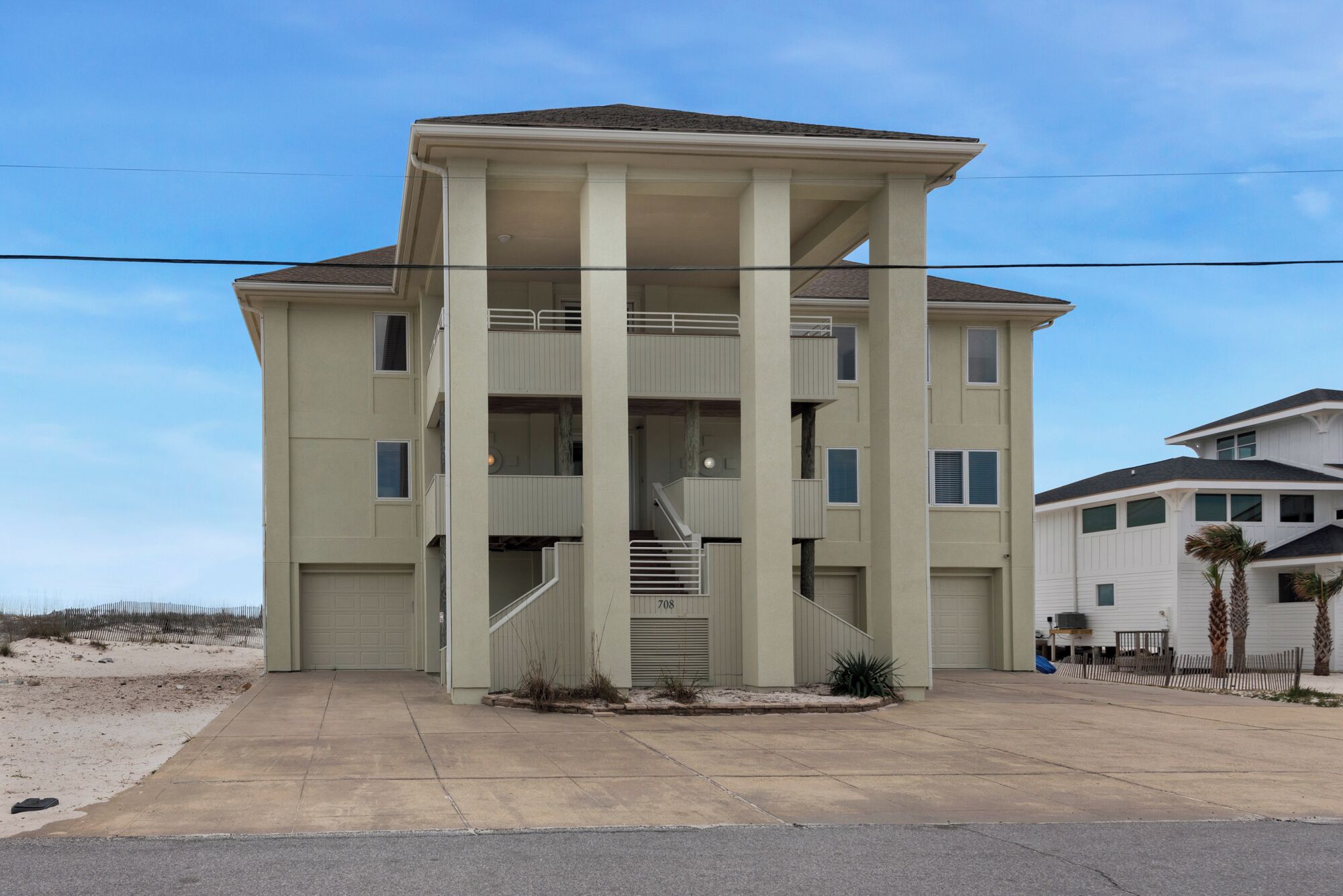 A multi-story residential building with a central staircase, multiple balconies, and a garage.