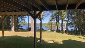 Un espace extérieur abrité offrant une vue sur un lac et des arbres.