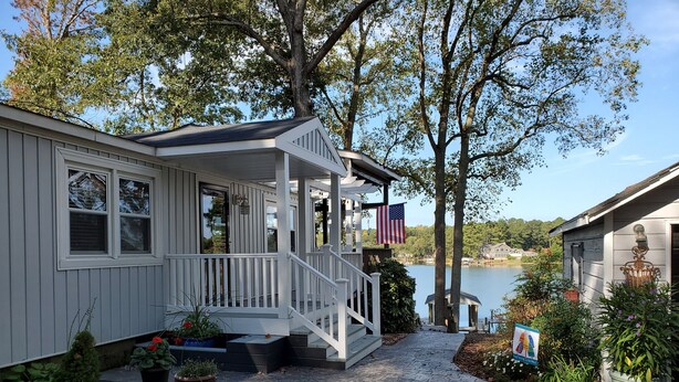 A house with a porch, a flag, and a view of a lake. - Waterfront with Private Pier and Tranquil Water views! (Gloucester Courthouse)