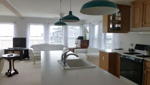 A modern kitchen with a central island, wooden cabinets, and pendant lighting. - Quiet North Beach Oceanfront Steps to Private Beach  3 Night Min Stays Available (North Beach)