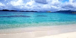 A beach with clear turquoise water, white sand, and distant mountains under a cloudy sky. - Blue Beach  Spectacular Caribbean Views  St Thomas (St Thomas)