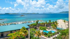 A resort with a pool, boats, and a view of the ocean. - Our Walk in Paradise Level at Sapphire Village, East End (St Thomas)