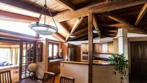 A spacious kitchen with wooden cabinets, a central island, and a dining area with chairs. - Oasis Retreat Nestled Near World Renown Hiking (Sedona)