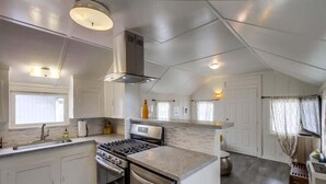 Een moderne keuken met witte kasten, een roestvrijstalen fornuis en een inbouwoven.