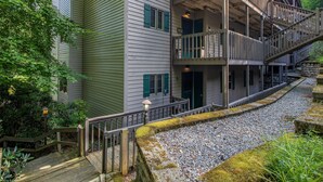 A multi-story building with a wooden deck and a stone pathway.
