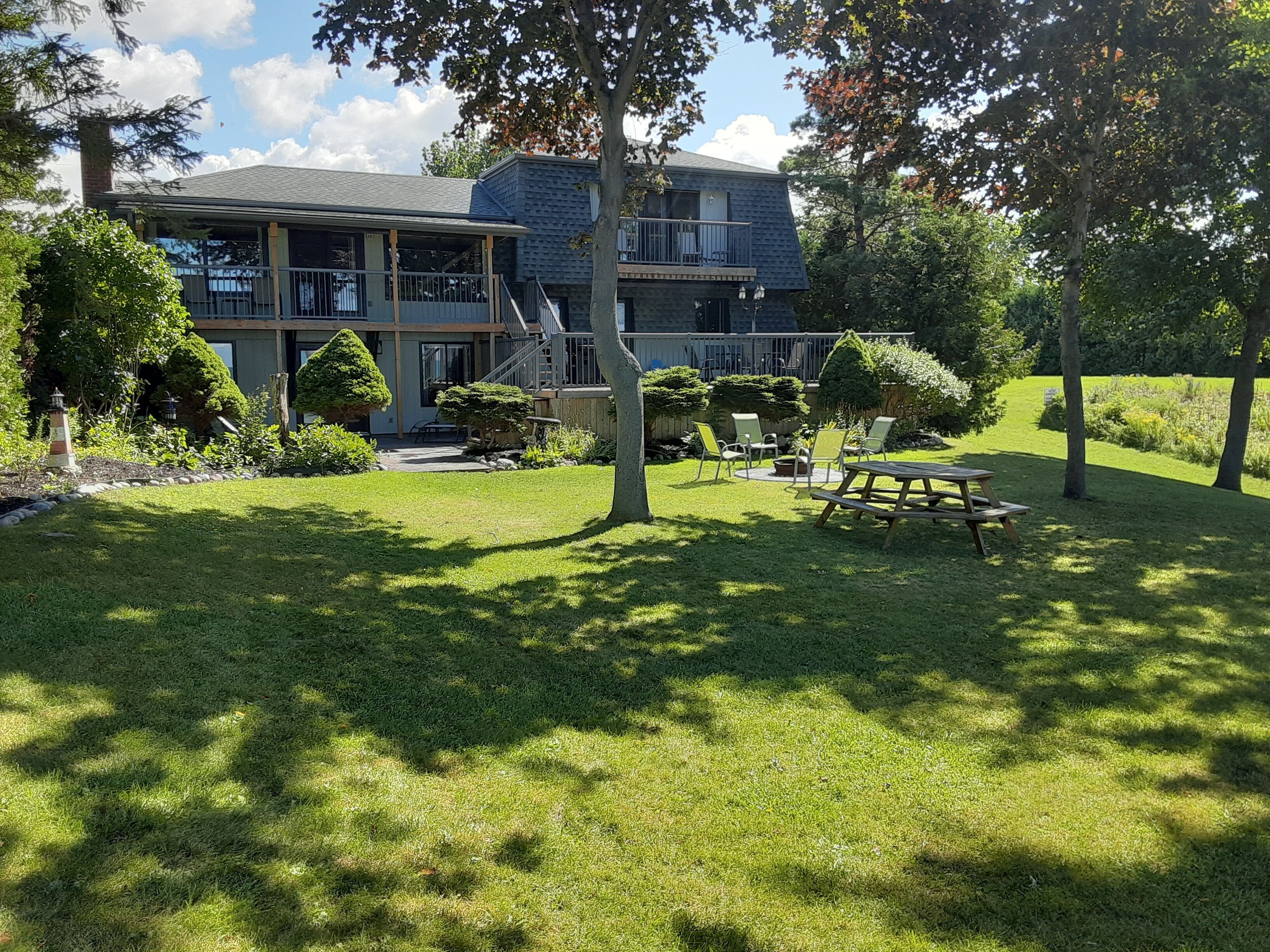 Back view of cottage facing lake.  Firepit and lots of open space
