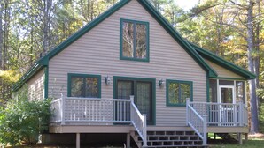 A two-story cabin with a front porch and a covered deck area. - Tranquil And Peaceful Vacation Getaway Just Waiting To Welcome You (Bristol)