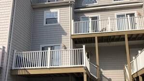 A multi-story residential building with a garage, a staircase, and a red truck parked in front. - Walk to everything downtown and beach (Dewey Beach)