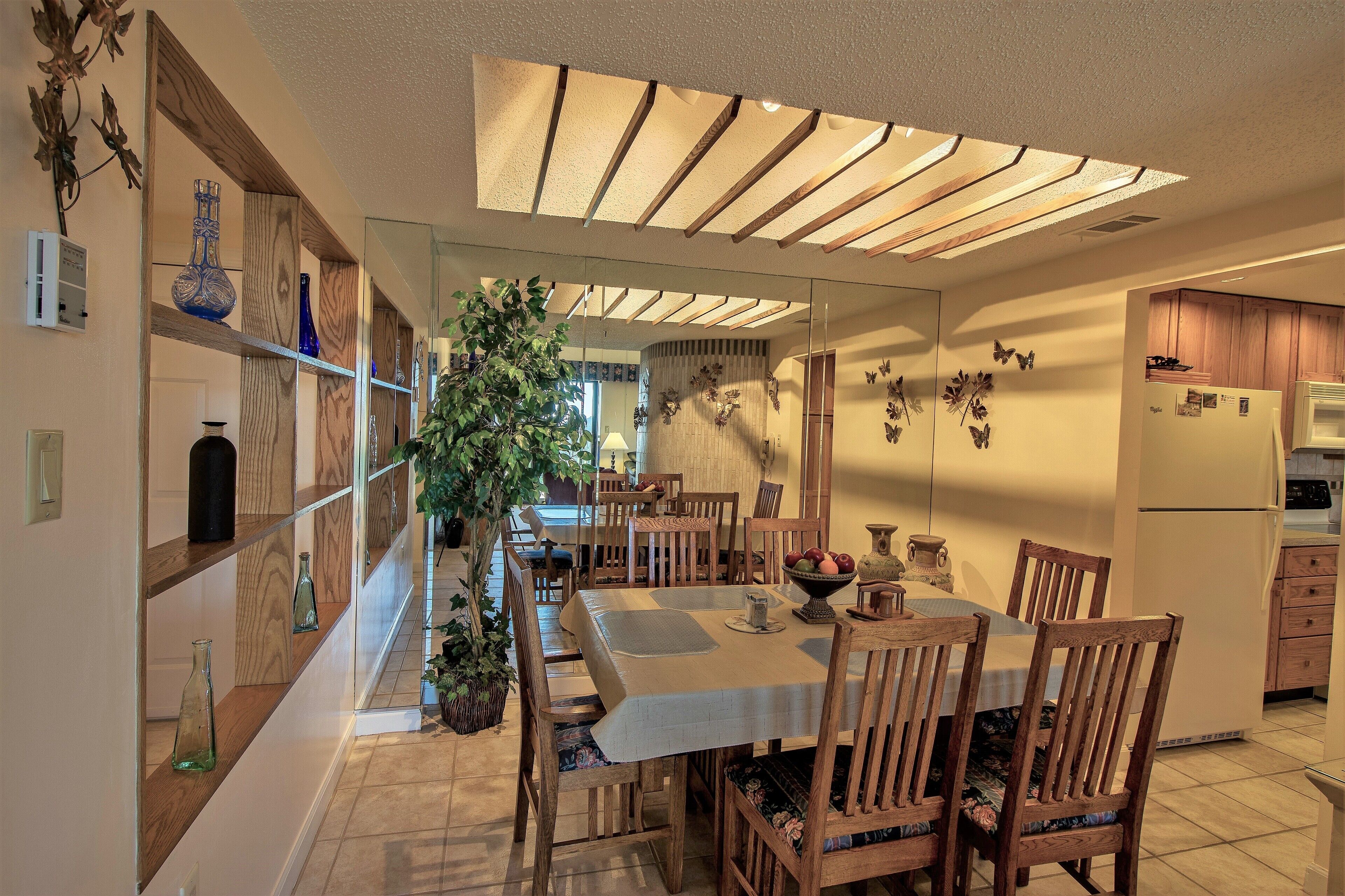 Una cocina moderna con armarios de madera, una mesa de comedor con sillas y un ventanal grande.