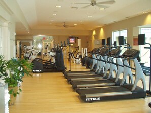 A gym with multiple treadmills, exercise machines, and a ceiling fan. - Amazing WATERVIEW in every room, 16 floor, PORTOFINO - oceanfront resort  (Gulf Breeze)