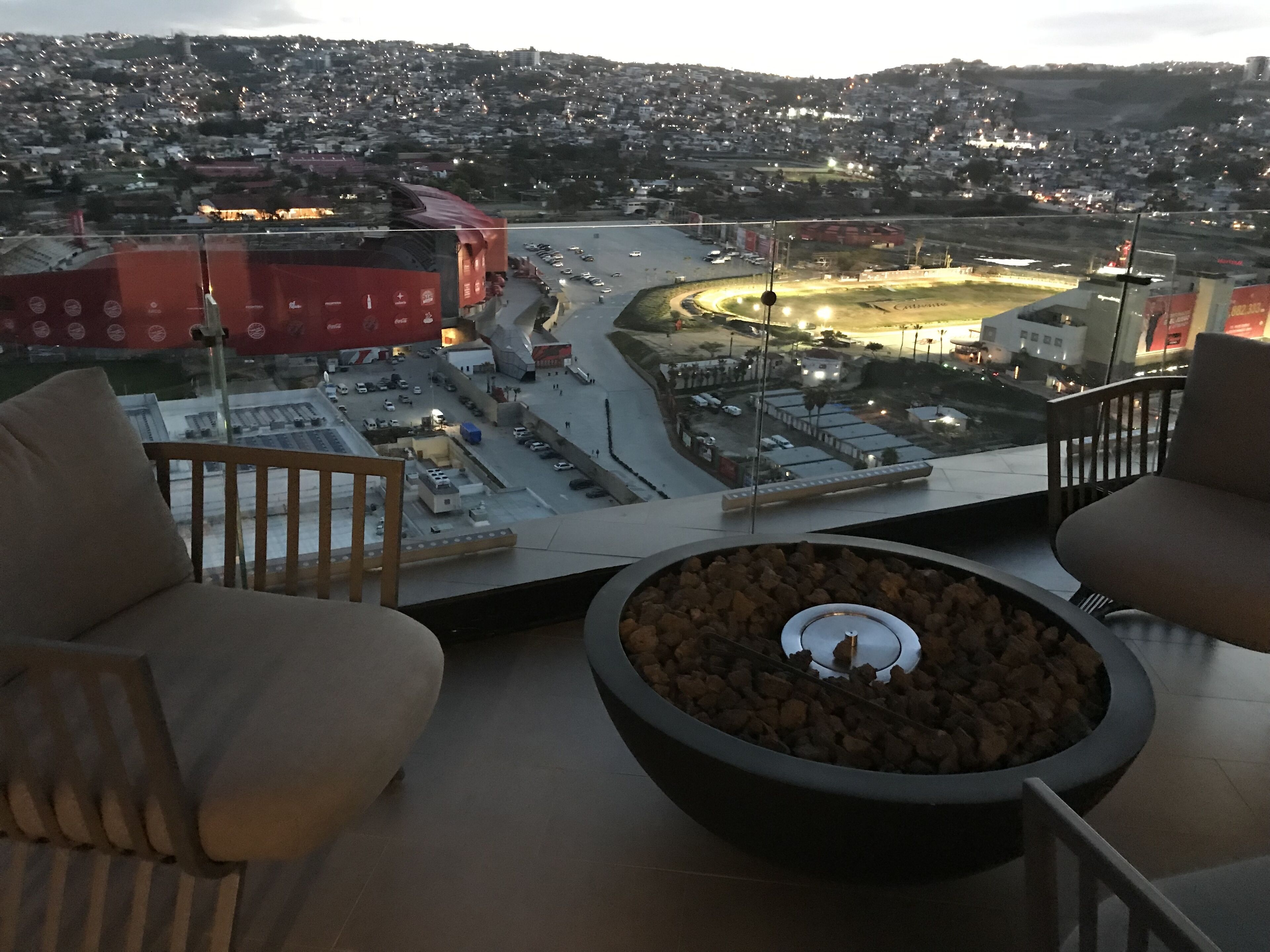 Un balcon avec vue sur la ville, un foyer extérieur et deux canapés.