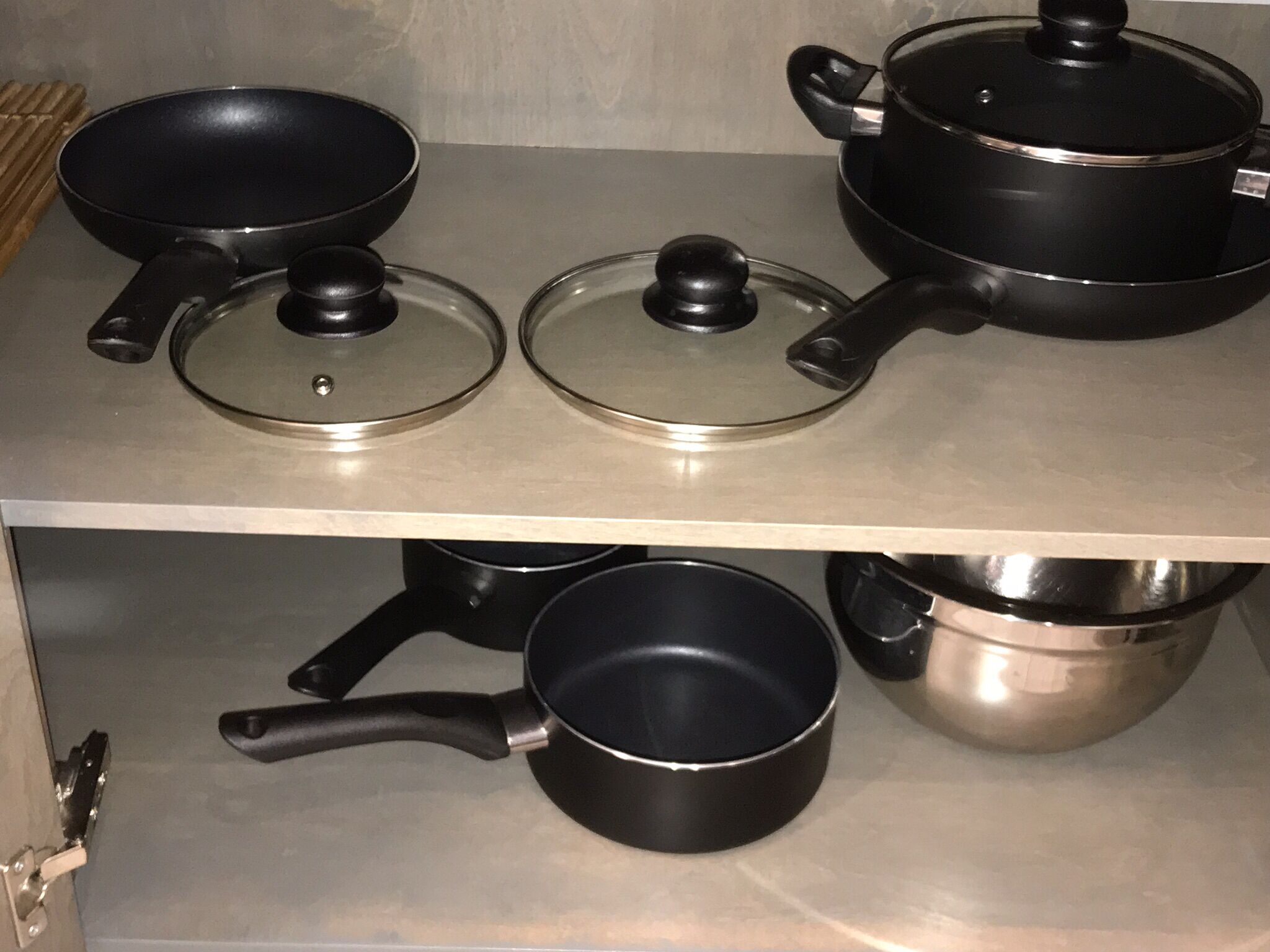A kitchen with stainless steel appliances and black cookware.