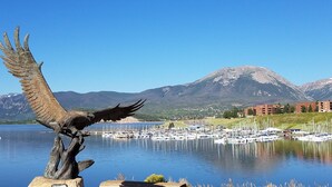 A marina with boats, a mountain in the background, and a statue of an eagle. - Dillon Lake 2 BR Condo-Pool, Hot Tub, 4 lift passes at Keystone-Breck & Arapahoe (Dillon)