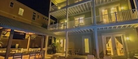 A multi-story hotel with a pool area, outdoor seating, and balconies.