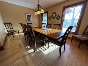 A dining room with a wooden table and chairs, a chandelier, and decorative wall mirrors. - Harvest Moon Lodge at Harvest Moon Cottages, LLC (Rockbridge)