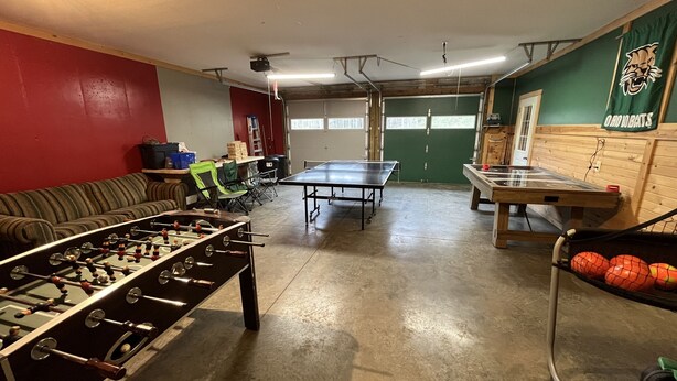 Ein Zimmer mit Kicker-, Tischtennis- und Pingpongtischen.