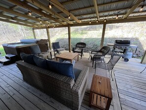 An outdoor patio with a wooden deck, wicker furniture, a hot tub, and a grill. - Harvest Moon Lodge at Harvest Moon Cottages, LLC (Rockbridge)