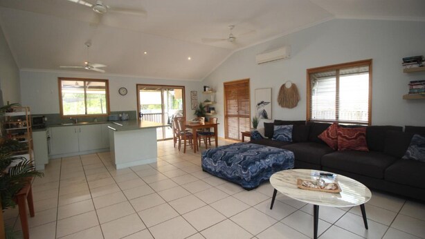 A spacious living area with a sofa, a coffee table, and a dining area with a table and chairs.