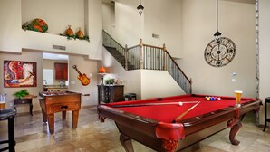 A spacious living area with a pool table, a foosball table, and a staircase leading to an upper level. - Arrowhead (Glendale)