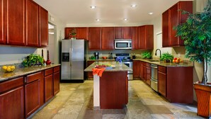 A modern kitchen with wooden cabinets, stainless steel appliances, and a central island. - Arrowhead (Glendale)