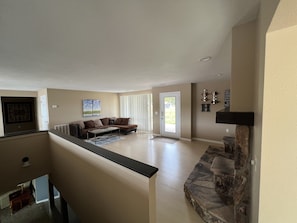 A spacious living area with a sofa, coffee table, and a stone fireplace.
