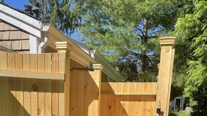 A wooden gate leading to a covered patio area with stone flooring. - Quintessential Cottage near beaches and Newport center. (Middletown)