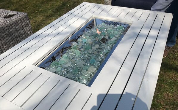 A rectangular outdoor water feature with a white border and a glass bottom filled with water and decorative elements.