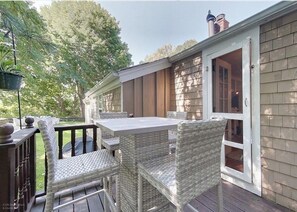 An outdoor patio with wicker furniture and a sliding glass door leading to a covered area.