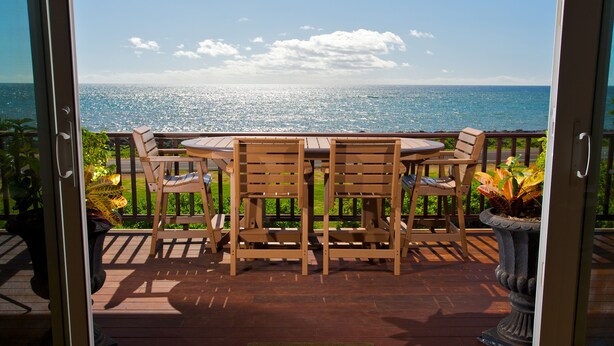 Una terraza de madera con una mesa y sillas, con vista a una masa de agua.