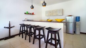 Een moderne keuken met een bar, een koelkast en een waterdispenser.