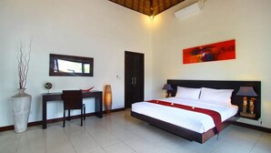 Een slaapkamer met een bed, bureau, stoel en een schilderij aan de muur.