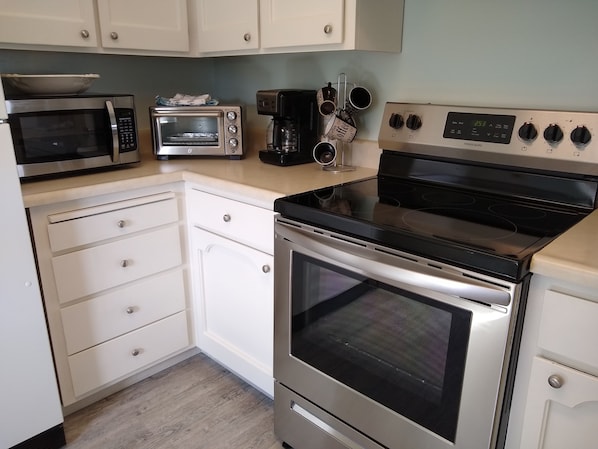 A kitchen with a microwave, toaster oven, coffee maker, and a stove. - Beautiful Lake Front house with Spectacular view, new deck/private dock sleep 6 (Clearlake)