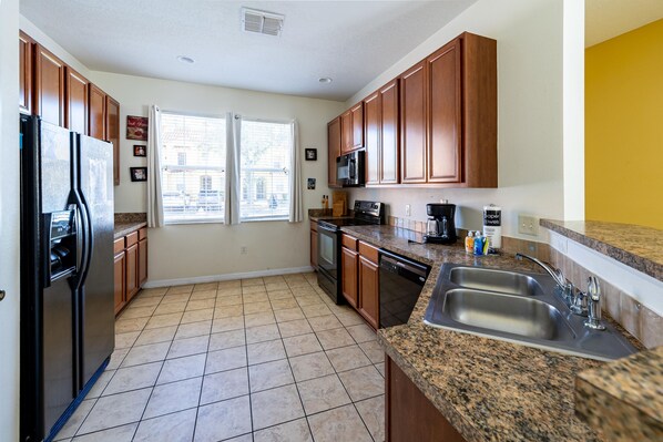 A kitchen with granite countertops, stainless steel appliances, and wooden cabinets.