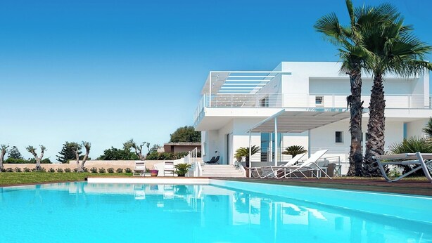 A modern two-story building with a pool, palm trees, and lounge chairs. - Villa Orizzonte, Marina Di Modica (Marina di Modica)