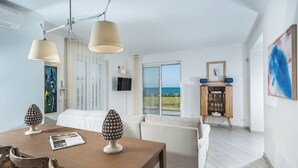 A modern living room with a dining area, large windows, and a view of the sea. - Villa Orizzonte, Marina Di Modica (Marina di Modica)