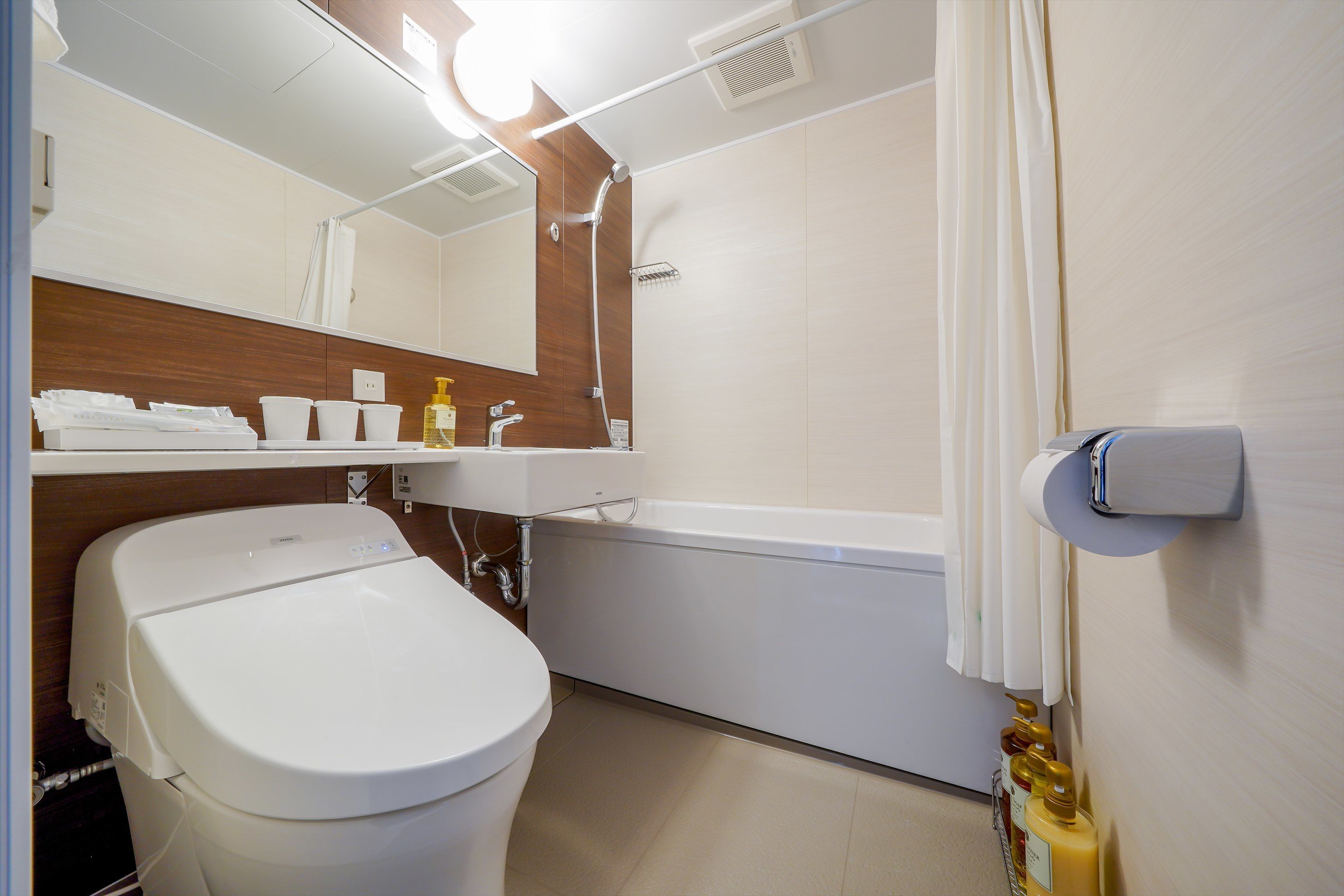 A modern bathroom with a toilet, sink, and bathtub.