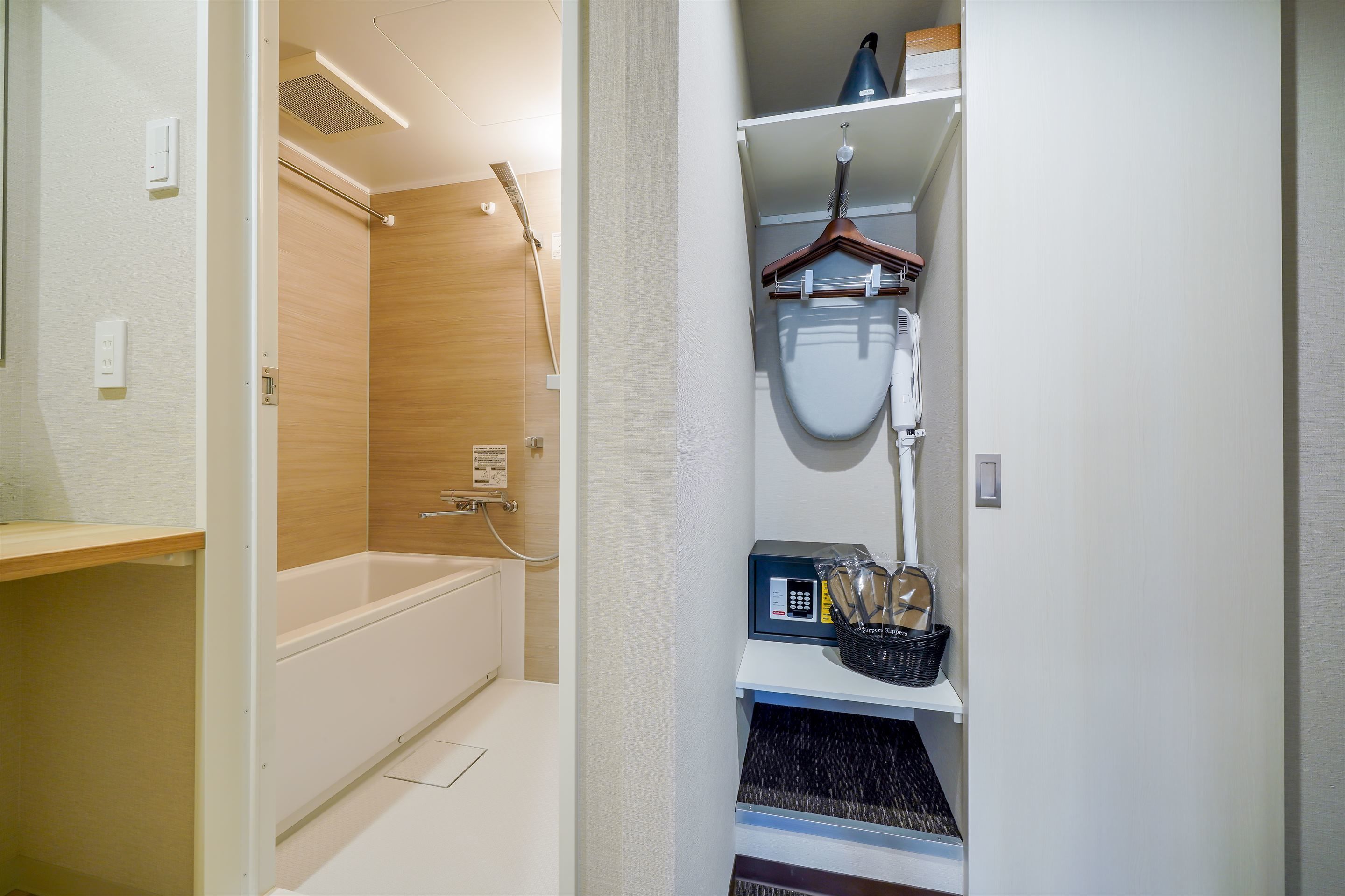 Ein modernes Badezimmer mit Badewanne, Dusche und Toilette. Ein Ablagefach mit Toilettenartikeln und ein Hängehandtuchhalter sind vorhanden.