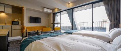 Habitación de hotel con una cama grande, un escritorio con silla, televisor y balcón con vistas.
