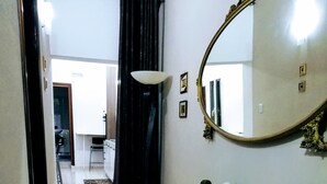 A hallway with a black rug, a small table with papers, a statue, and a mirror on the wall. - Catania House single apartment sleeps 4 near the new Garibaldi  (Catania)