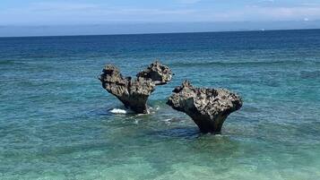 On peut clairement distinguer une côte rocheuse avec deux formations rocheuses imposantes qui émergent de l’eau.