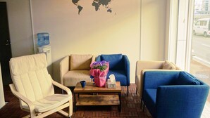 Un espace détente avec une carte du monde accrochée au mur, un distributeur d’eau et une table basse agrémentée d’un bouquet de fleurs.