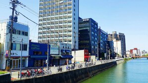 Un bâtiment moderne à plusieurs étages, une enseigne indiquant « KCS », et une façade bleue avec une enseigne pour un café.