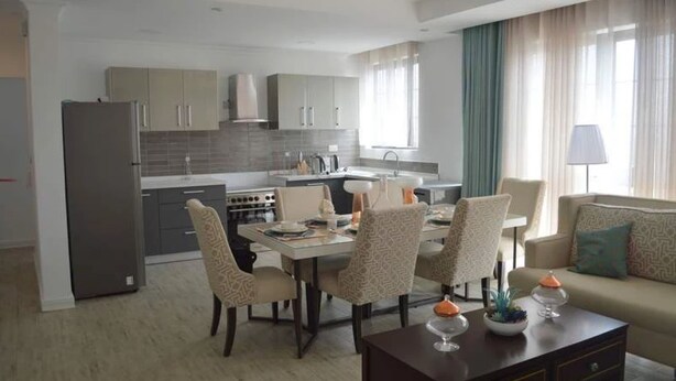 A modern apartment with a dining area, kitchen, and living room. - Serene Crest Apartments (Kigali)