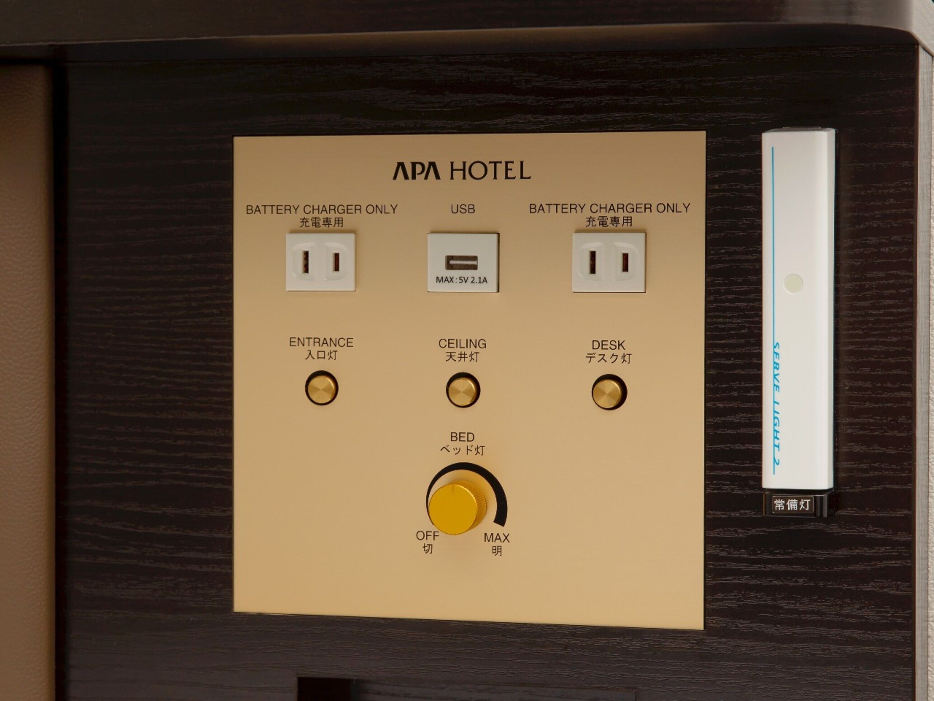A control panel with battery charger sockets, labeled "APA HOTEL," and switches for entrance, ceiling, desk, and bed lighting.