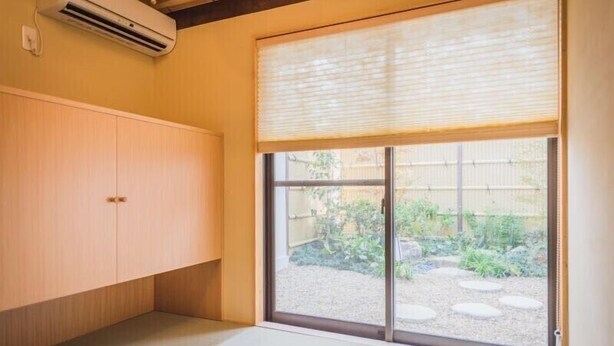 A room with tatami flooring, a sliding door to a garden, and a wooden wardrobe. - Kyoto Tanbaguchi Classic Japanese House (Kyoto)
