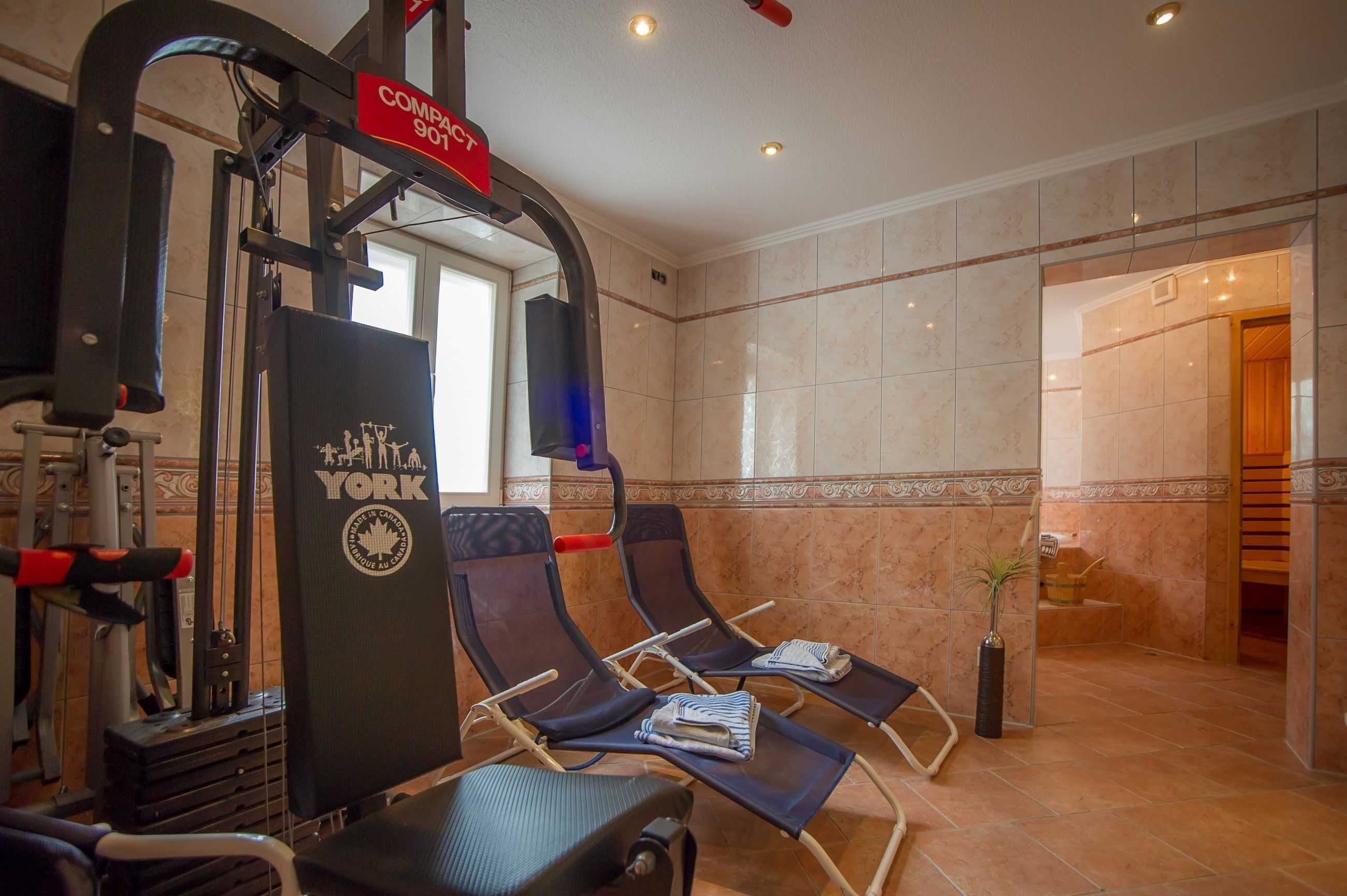 Une salle de sport équipée de matériel d’exercice, avec deux fauteuils et un panneau indiquant « SOCIÉTÉ 901 ».