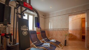 Un gimnasio con equipo de ejercicio, dos sillones de descanso y un letrero que dice 'COMPANY 901'.
