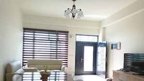 Una sala de estar con una mesa de comedor, sofá y mueble para televisión.